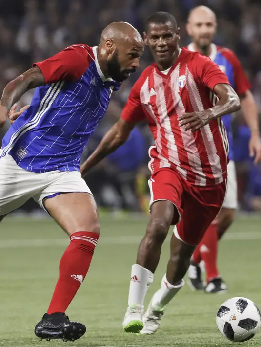 Penyerang Thierry Henry membawa dari kejaran Aldair saat pertandingan tim Prancis 98 dengan tim FIFA 98 di Arena U, Nanterre, Paris (12/6). Pertandingan ini memperingati 20 tahun kemenangan Prancis di Piala Dunia 1998. (AFP Photo/Thomas Samson)