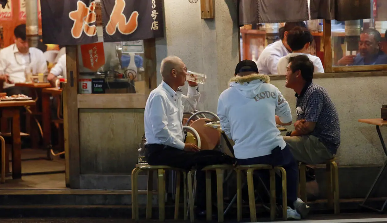 Orang-orang menikmati minuman di sebuah bar di Tokyo, Jepang, 4 Oktober 2021. Warga kembali beraktivitas setelah berakhirnya status pembatasan darurat virus corona COVID-19 di Jepang. (AP Photo/Koji Sasahara)