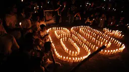 Di Padang, Sumatera Barat, sejumlah orang menyalakan lilin dan membentuk angka 60. Gerakan Earth Hour ini merupakan aksi dalam rangka untuk mengurangi pemanasan global yang dilakukan dengan mematikan lampu selama 60 menit (ANTARA FOTO/Iggoy el Fitra)