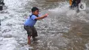 Seorang anak bemain air banjir yang merendam Jalan Benteng,  Duta Kranji, Kalibaru, Bekasi, Jawa Barat, Jumat (24/2/2023). Hujan yang turun di Bekasi sejak Kamis malam mengakibatkan sejumlah wilayah di Bekasi tergenang hingga lebih dari 50 cm. (merdeka.com/Imam Buhori)