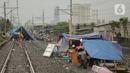 Pengungsi banjir mendirikan tenda di jalur rel kereta commuterline Tangerang-Duri di Kembangan Baru, Jakarta, Jumat (3/1/2020). Jalur rel yang nonaktif sementara karena banjir dimanfaatkan warga sekitar untuk mendirikan tenda darurat karena rumah mereka masih terendam. (Liputan6.com/Faizal Fanani)