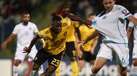 Striker Belgia, Michy Batshuayi, berebut bola dengan bek San Marino, Davide Simoncini, pada laga Kualifikasi Piala Dunia 2022 di Olympic Stadium, Serravalle, Jumat (6/9). San Marino kalah 0-4 dari Belgia. (AFP/Isabella Bonotto)