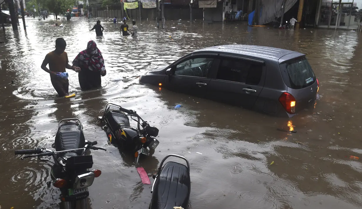 Sejumlah kendaraan terjebak banjir setelah hujan lebat di Lahore (16/7/2019).Banjir bandang merusak lebih dari 120 rumah, 30 toko dan melumpuhkan pasokan air dan listrik. (AFP Photo/Arif Ali)