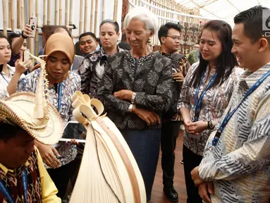 Managing Director IMF Christine Lagarde menyaksikan musikus memainkan sasando saat berkunjung ke Paviliun Indonesia di arena pertemuan IMF-Bank Dunia, Bali, Rabu (10/10). Christine terpesona dengan berbagai budaya Nusantara. (Liputan6.com/Angga Yuniar)