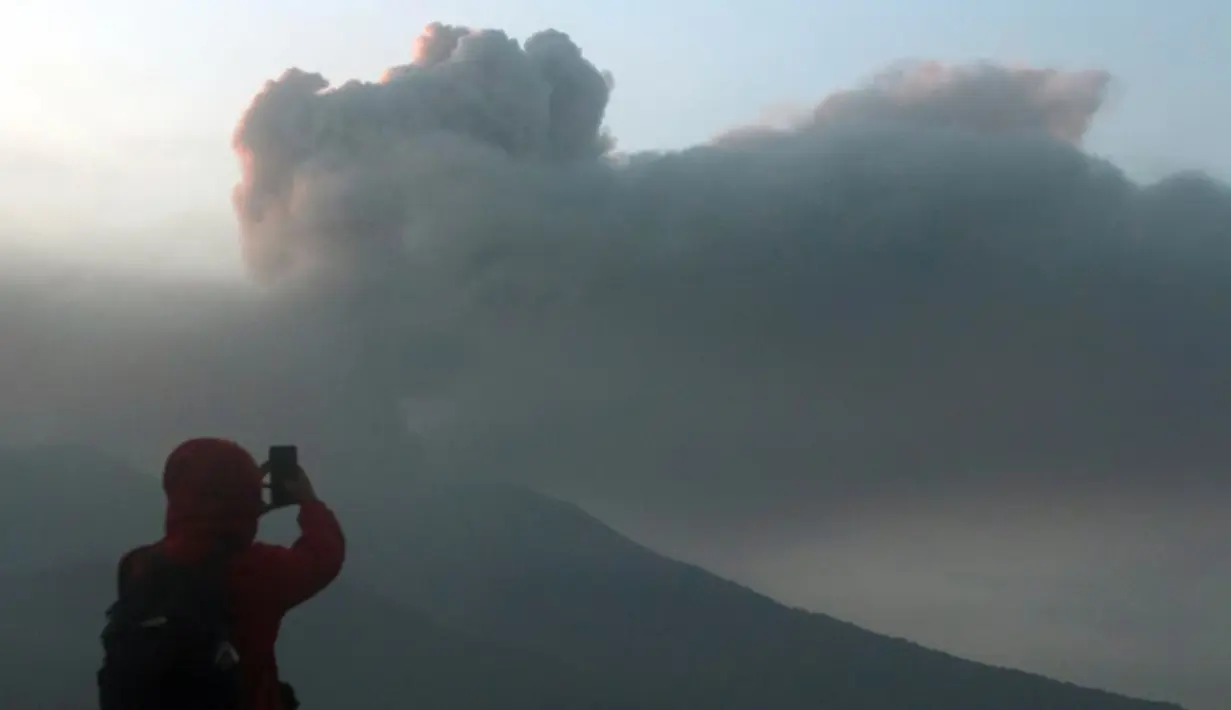 Para petani yang berada di sekitar lereng Gunung Marapi tetap melakukan aktivitas. Padahal, pemerintah desa setempat telah memberikan larangan beraktivitas di sekitar gunung sementara waktu. (ADI PRIMA/AFP)