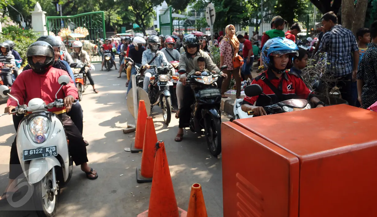 Puluhan pengendara motor mengantri untuk masuk ke dalam areal Monumen Nasional, Jakarta, Jumat (1/1/2016). Hari libur tahun baru 2016 dimanfaatkan ribuan warga untuk berwisata di kawasan Monumen Nasional. (Liputan6.com/Helmi Fithriansyah)
