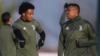 Gelandang Juventus, Juan Cuadrado (kiri) berbincang dengan bek Alex Sandro saat mengikuti sesi latihan jelang menghadapi Barcelona dalam matchday kelima Liga Champions grup D di 'Juventus Training Center' di Vinovo (21/11). (AFP Photo/Marco Bertorello)