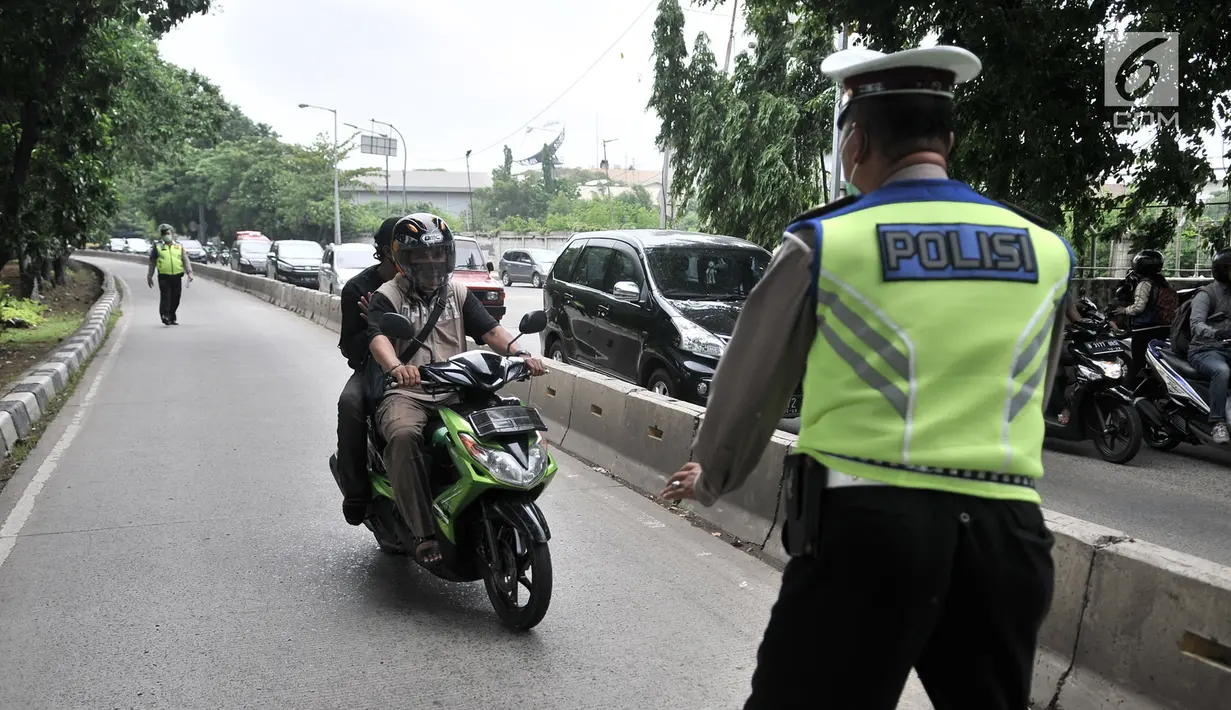 Polisi memberhentikan sepeda motor yang melintasi jalur bus Transjakarta di Jalan Yos Sudarso, Jakarta, Senin (21/1). Razia ini sekaligus meningkatkan kedisiplinan dalam berkendara. (Merdeka.com/Iqbl Nugroho)