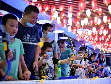 Sejumlah anak mencoba memanah dalam acara perayaan Festival Pertengahan Musim Gugur di Museum Hainan, Haikou, ibu kota Provinsi Hainan, China selatan (1/10/2020). (Xinhua/Guo Cheng)