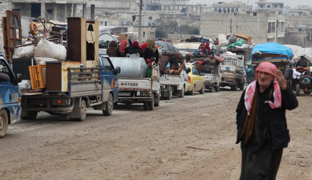 Sejumlah kendaraan sarat barang melewati Kota Ariha, Provinsi Idlib, Suriah, Rabu (29/1/2020). Kemajuan serangan pasukan pemerintah Suriah yang didukung Rusia atas Idlib memaksa ratusan ribu warga mengungsi ke tempat lebih aman. (Abdulaziz KETAZ/AFP)
