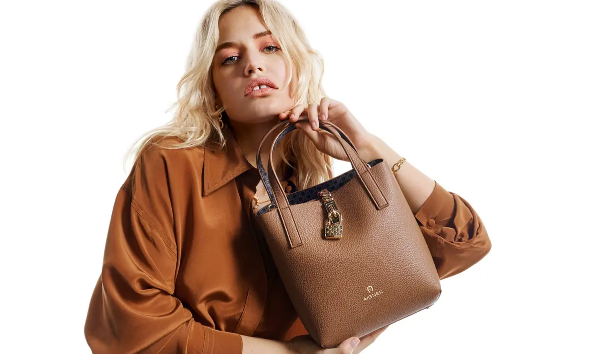 Serta piyama sutra berwarna cokelat menciptakan keseluruhan tampilan yang elegan dengan Tas LEONIE.  [Dok. Aigner]