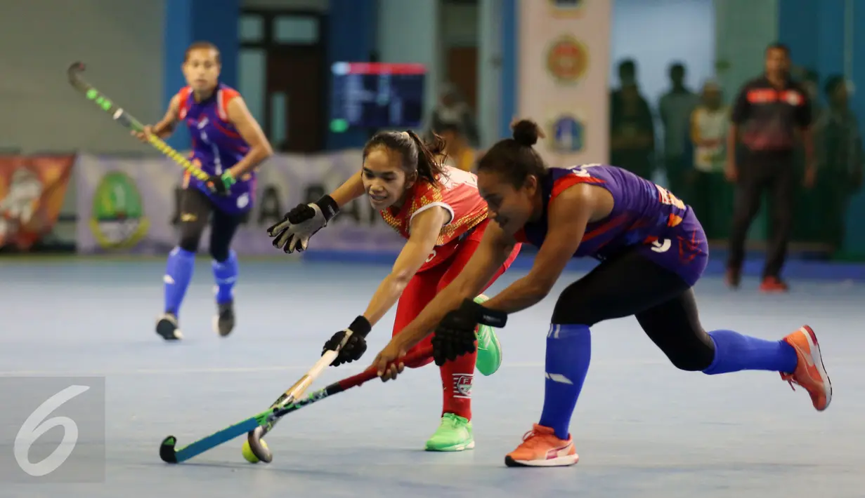Pemain hoki putri DKI Jakarta, Sismiya Winarsih (tengah) berebut bola dengan pemain Papua di laga final PON XIX Jabar di Gymnasium UPI, Bandung, Senin (19/9/2016). DKI Jakarta meraih emas setalah unggul 4-2 atas Papua. (Liputan6.com/Helmi Fithriansyah)