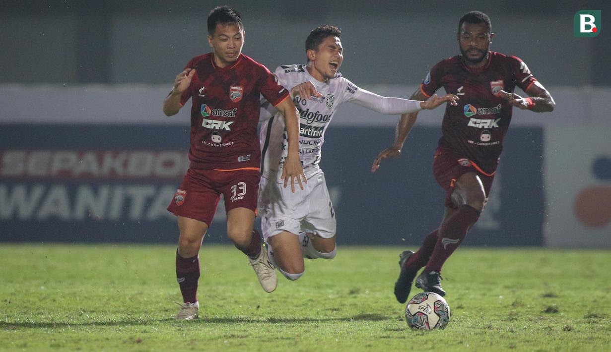 Pemain Bali United, Ricky Fajrin (tengah) berebut bola dengan pemain Borneo FC, Wahyudi Setiawan Hamisi (kiri) dalam laga pekan ke-5 BRI Liga 1 2021/2022 di Stadion Indomilk Arena, Tangerang, Selasa (28/09/2021). Kedua tim bermain imbang 1-1. (Bola.com/Bagaskara Lazuardi)