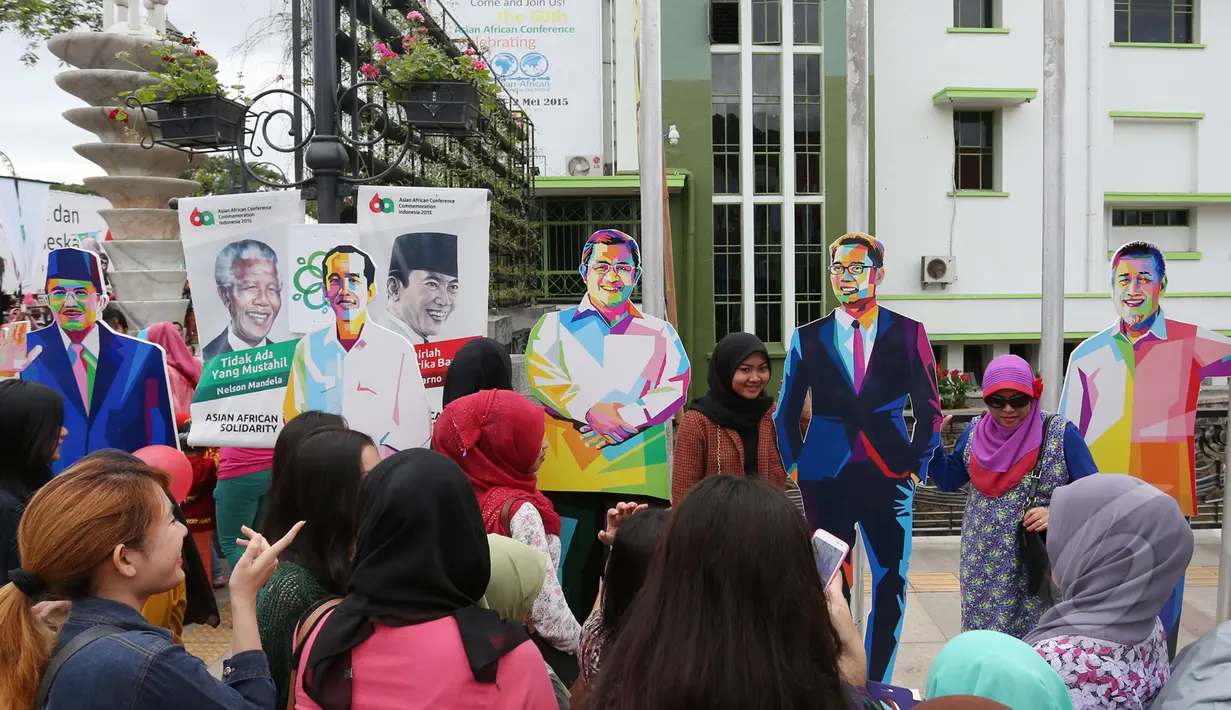 Ribuan warga berbondong-bondong untuk melihat karnaval KAA, Bandung, Sabtu (26/4/2015). Sejumlah warga terlihat berfoto di tengah keramaian suasana parade KAA. (Liputan6.com/Herman Zakharia)