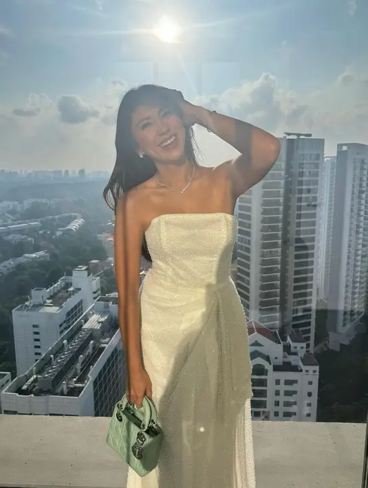 Sedangkan di sini Tyna Dwi Jayanti tampil penuh pesona mengenakan strapless dress berwarna putih, yang ia padukan dengan tas tangan berwarna hijau pastel. [Foto: Instagram/tynadwijayanti]