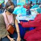 Vaksinator menyuntikkan vaksin Covid-19 ke seorang peserta vaksinasi massal di Stadion Gajayana, Kota Malang pada Sabtu, 7 Agustus 2021 (Liputan6.com/Zainul Arifin)
