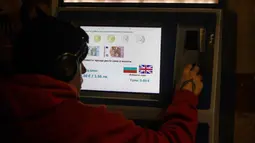 Keputusan ini menjadikan Bulgaria sebagai negara ke-21 yang bergabung dalam kawasan zona euro. Tampak dalam foto, seseorang membeli tiket dari mesin yang menunjukkan uang kertas dan koin euro mana yang akan diterima, di Sofia, Bulgaria, Kamis 1 Januari 2026, saat negara tersebut bergabung dengan serikat mata uang euro. (AP Photo/Valentina Petrova)