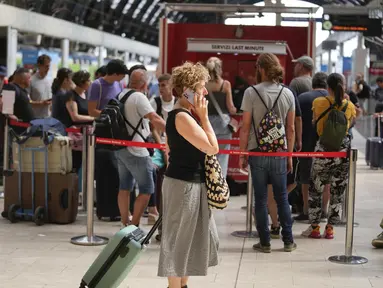 Penumpang mengantre di loket tiket Trenitalia di stasiun pusat Milan selama pemogokan kereta api nasional, Kamis, 13 Juli 2023. (AP Photo/Luca Bruno)