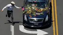 Seorang penggemar berlari mengejar mobil jenazah mantan petinju dunia, Muhammad Ali yang sedang menuju pemakaman di Louisville, Kentucky, Amerika Serikat, Jumat (10/6). (REUTERS / Adrees Latif)