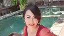 Pose Tessa Kaunang saat menikmati floating breakfast di Bali. Dia tampil berani mengenakan baju merah mentereng transparan, memperlihatkan bra hitam dan celana gemasnya. (Instagram/tessakaunang_tuiit)
