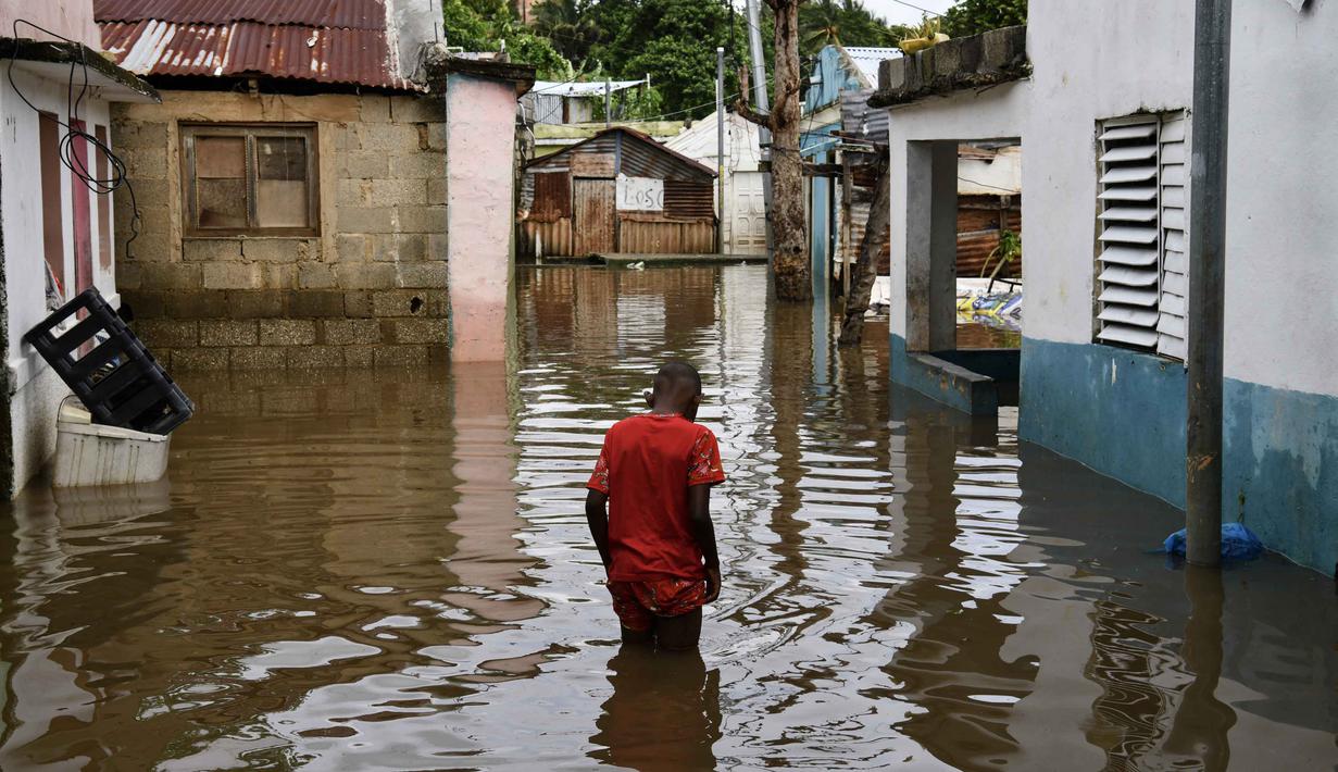 Seorang pria berjalan di sepanjang jalan yang terendam banjir setelah badai tropis Melissa berlalu sebelum berubah menjadi badai di kawasan Las Cucarachas di Santo Domingo, Republik Dominika pada Selasa 28 Oktober 2025. (Danny Polanco/AFP)