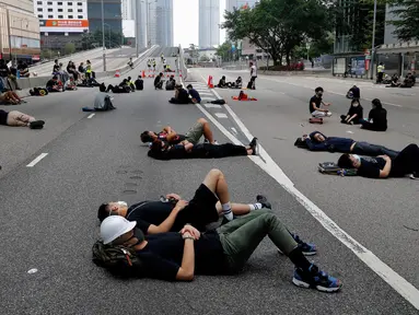 Sejumlah pengunjuk rasa tidur di jalanan utama dekat Gedung Dewan Legislatif saat menggelar protes terkait RUU Ekstradisi di Hong Kong, Senin (17/6/2019). Sekitar dua juta warga Hong Kong turun ke jalan menentang RUU Ekstradisi. (AP Photo/Vincent Yu)