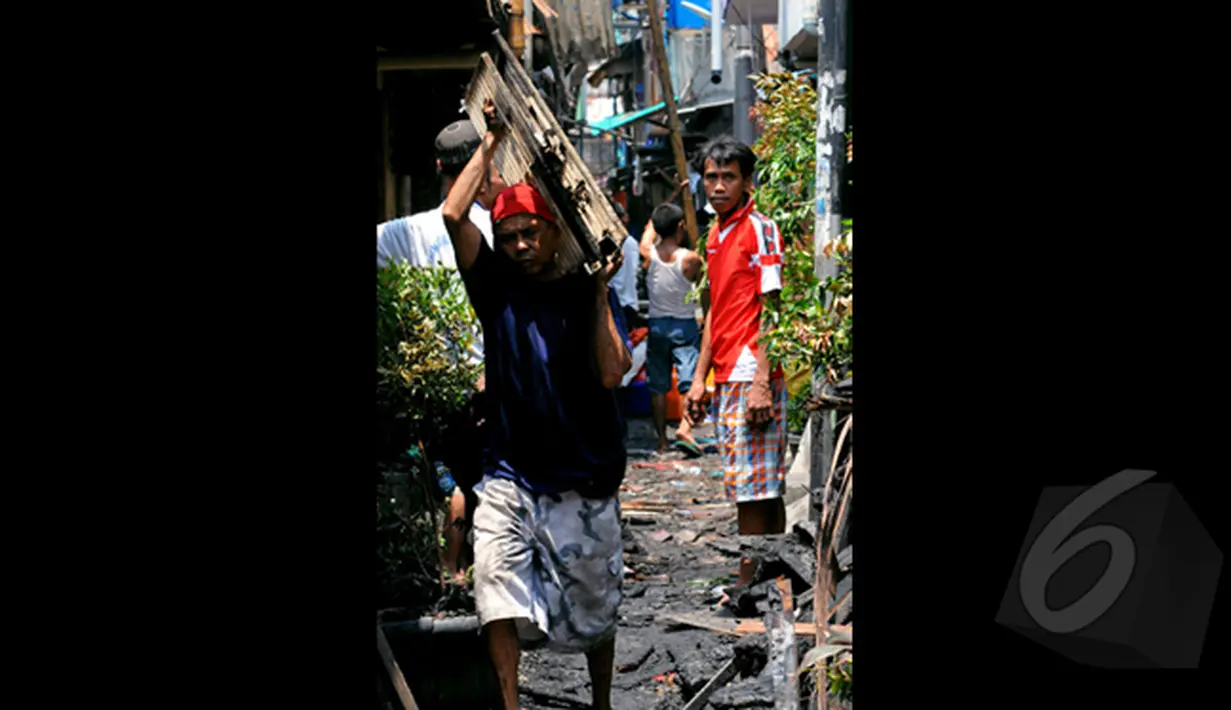 Tampak seorang warga mengangkat barang miliknya usai kebakaran, di Karang Anyar, Sawah Besar, Jakarta, Selasa, (24/2/2015). Kebakaran yang melanda 14 Rukun Tetangga (RT) ini menyebabkan 2.000 warga kehilangan tempat tinggal. (Liputan6.com/Faisal R Syam)