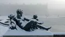 Salju menyelimuti sebuah patung di tepi kolam utara di taman Versailles, luar Kota Paris pada Selasa 6 Januari 2026. Sejumlah negara di Eropa dilanda cuaca ekstrem usai badai salju menerjang wilayah-wilayah tersebut pada Senin, 5 Januari 2026, waktu setempat. (GEOFFROY VAN DER HASSELT/AFP)