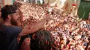 Puluhan ribu orang berkumpul pada festival La Tomatina di desa Bunol, Spanyol, Rabu (30/8). Lebih dari 20.000 peserta hadir di acara tahunan yang diselenggarakan setiap Rabu terakhir di bulan Agustus. (Alberto Saiz/AP)