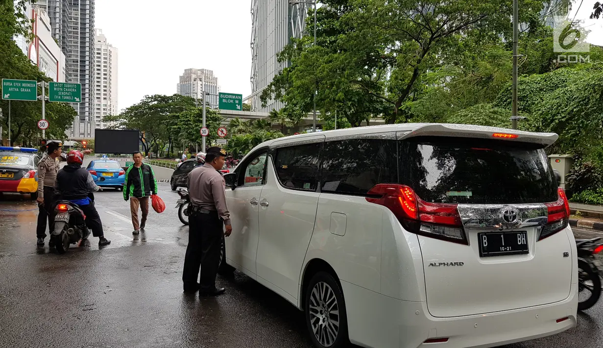 Petugas kepolisian memberikan informasi lalu lintas kepada pengemudi usai balkon BEI ambruk di kawasan SCBD, Jakarta, Senin (15/1). (Liputan6.com/Herman Zakharia)
