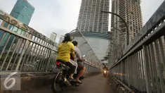 Pengendara sepeda motor melintas di atas Jembatan Penyeberangan Orang (JPO) di kawasan Grogol, Jakarta, Rabu (4/5). JPO yang seharusnya diperuntukkan bagi pejalan kaki itu kini sering dimanfaatkan pengendara motor. (Liputan6.com/Gempur M Surya)
