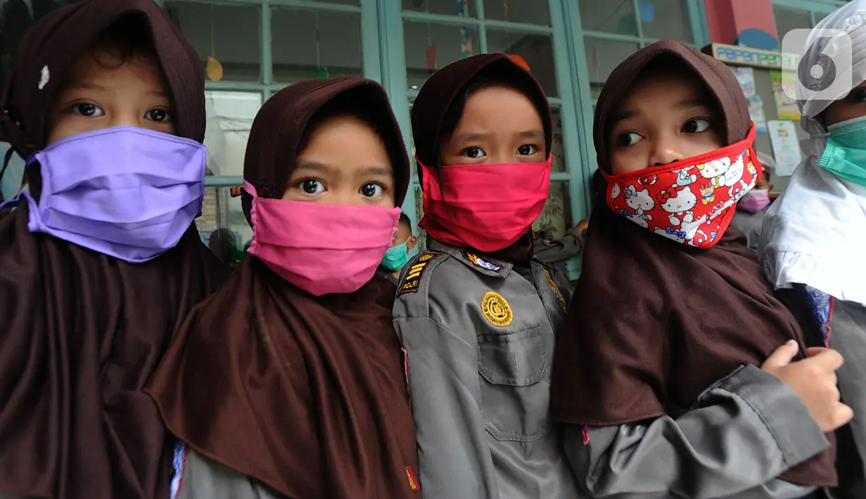 Murid Taman Kanak-kanak (TK) mengenakan masker di  TK RA Hidayatusshibyan Cinere, Depok, Kamis (5/3/2020). Mengantisipasi virus corona COVID-19, murid-murid diukur suhu tubuhnya  dan diwajibkan mencuci tangan mereka sebelum masuk kelas.  (merdeka.com/Arie Basuki)