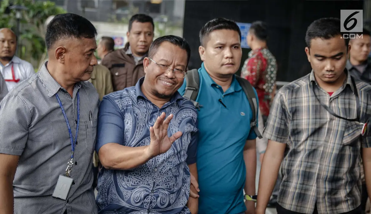 Anggota DPRD Provinsi Jambi Supriyono menyapa awak media saat dibawa ke Gedung KPK, Jakarta, Rabu (29/11). Dalam operasi senyap yang dilakukan KPK kemarin, ada sekitar 11 orang yang diciduk di Jambi dan Jakarta. (Liputan6.com/Faizal Fanani)