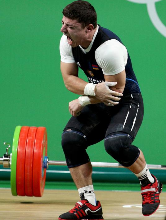 Atlet angkat besi Armenia, Andranik Karapetyan berteriak kesakitan usai mengalami cedera horor ketika tampil pada Olimpiade 2016 di Rio de Janeiro, Rabu (10/8). Siku Karapetyan patah saat hendak mengangkat beban 195 kilogram (REUTERS/Stoyan Nenov)