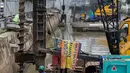 Pekerja menyelesaikan pemasangan dinding turap di kali pasar baru, Jakarta, Rabu (9/3/2022). Dinas Sumber Daya Air DKI Jakarta melakukan pemasangan turap bertujuan untuk mengantisipasi banjir serta tanah ambles di pinggir sungai. (Liputan6.com/Faizal Fanani)