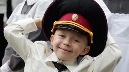 Seorang taruna muda tersenyum ketika menghadiri upacara pada hari pertama sekolah di salah satu sekolah Kadet terbaik, lyceum, di Kiev, Senin (3/9). Ukraina menandai Hari Pengetahuan, sebagai dimulainya tahun ajaran baru. (AP Photo/Efrem Lukatsky)