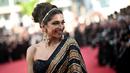 <p>Aktris India dan anggota Juri Seleksi Resmi Deepika Padukone tersenyum saat dia tiba untuk menghadiri pemutaran film "Final Cut (Coupez !)" menjelang upacara pembukaan Festival Film Cannes edisi ke-75 di Cannes, Prancis selatan (17/5/2022). (AFP Photo/LOIC VENANC)</p>