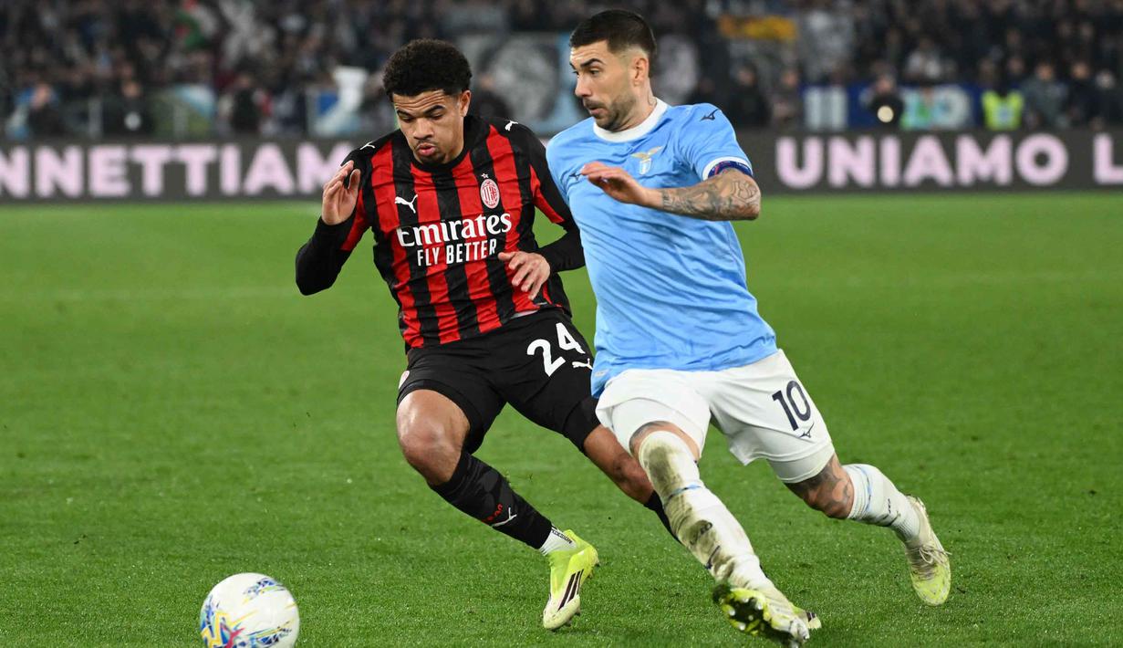 Memasuki babak kedua, AC Milan langsung tancap gas. Rossoneri mencoba untuk mengejar ketertinggalan. Tampak dalam foto, bek AC Milan asal Swiss, Zachary Athekame (kiri), berebut bola dengan gelandang Lazio asal Italia, Mattia Zaccagni (kanan), selama pertandingan pekan ke-29 Serie A Italia 2025/2026 di Olimpico Stadium, Roma, Minggu 15 Maret 2026 waktu setempat atau Senin (16/3/2026) dini hari WIB. (Alberto PIZZOLI/AFP)