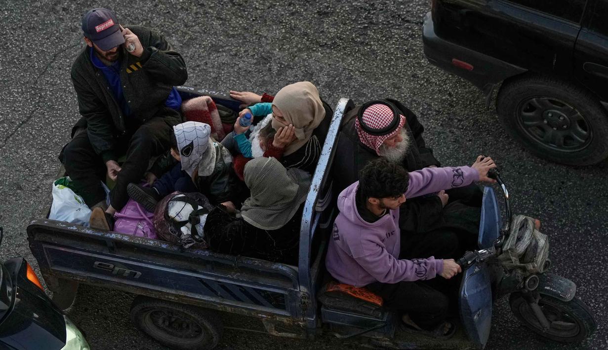 Diketahui, militer Israel mengeluarkan perintah evakuasi bagi penduduk di Lebanon selatan dan pinggiran Beirut sebelum melancarkan serangan yang menargetkan pusat komando dan infrastruktur Hizbullah. Tampak dalam foto, sebuah keluarga melarikan diri dari serangan udara Israel di Dahiyeh, pinggiran selatan Beirut, dengan mengendarai kendaraan bermotor roda tiga yang dikenal sebagai "tok-tok," di Beirut, Lebanon, Kamis 5 Maret 2026. (AP Photo/Bilal Hussein)