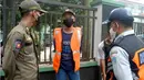 Petugas Satpol PP dan Dishub berbicara dengan warga yang terjaring operasi tertib masker dalam rangka penerapan protokol kesehatan COVID-19 di Jalan Fatmawati, Jakarta, Kamis (10/3/2022). (merdeka.com/Arie Basuki)