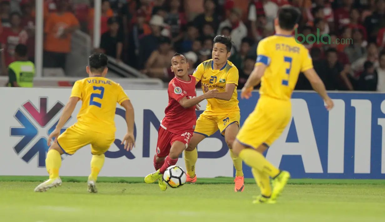 Pemain Persija Jakarta, Riko Simanjuntak berusaha melewati kepungan para pemain Song Lam Nghe An FC pada laga Piala AFC 2018 di Stadion Utama GBK, Senayan, Jakarta, (13/3/2018). Persija Jakarta menang 1-0. (Bola.com/Nick Hanoatubun)