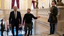 Presiden Joe Biden (kiri) bersama Presiden Ukraina Volodymyr Zelensky menaiki tangga di Istana Mariinsky, Kyiv, Ukraina pada tanggal 20 Februari 2023. Presiden AS Joe Biden menjanjikan peningkatan pengiriman senjata untuk Ukraina selama kunjungan mendadak ke Kyiv pada 20 Februari 2023, di mana ia juga menjanjikan komitmen Washington dalam membela integritas teritorial Ukraina. (Evan Vucci/POOL/AFP)