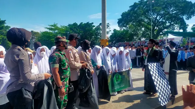 Ribuan santri peserta upacara perwakilan dari seluruh Kecamatan di Garut, berbaur bahu-membahu memunguti sampah di pelataran Lapangan Otista, Alun-alun Garut, lokasi dilangsungkannya upacara HSN di Garut. (Liputan6.com/Jayadi Supriadin)