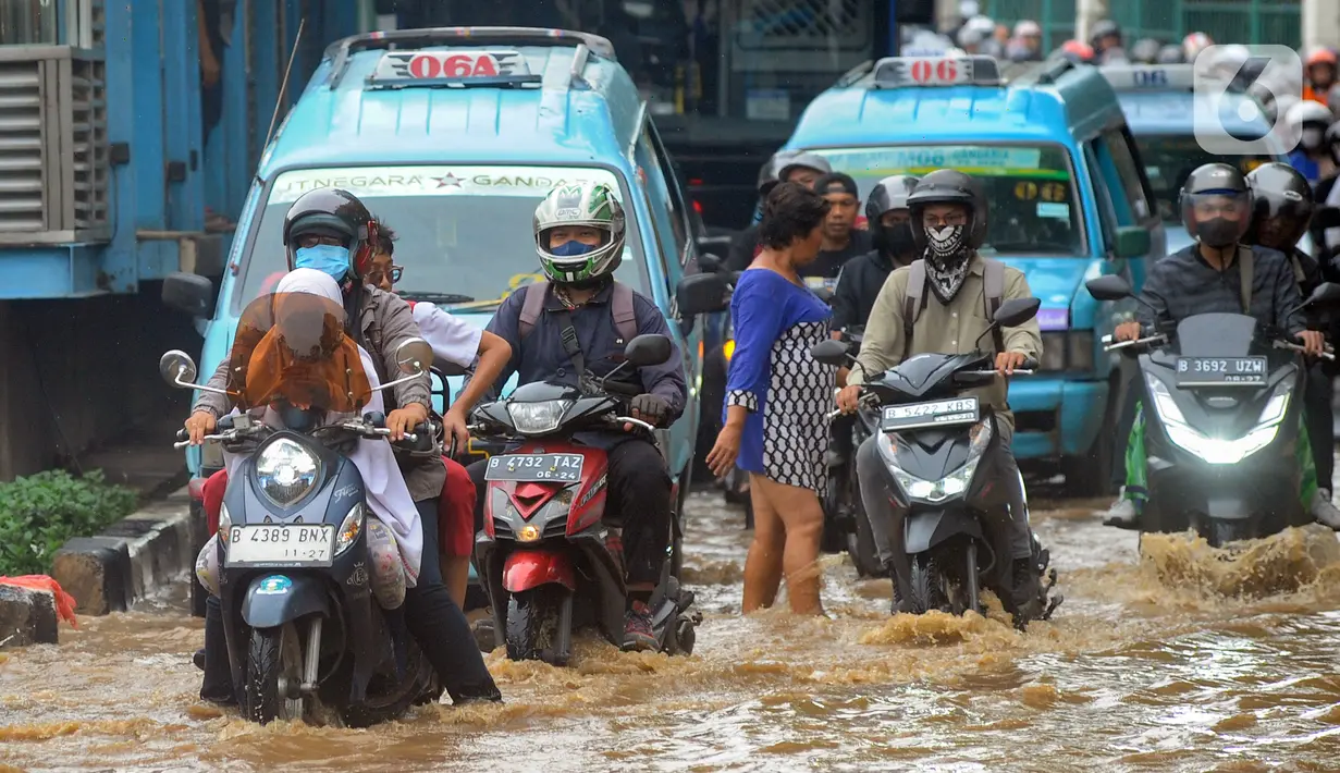 Pengendara menerobos banjir yang meggenang di Jalan Raya Bogor depan Pasar Induk Kramat Jati, Jakarta, Kamis (30/11/2023). (merdeka.com/Arie Basuki)