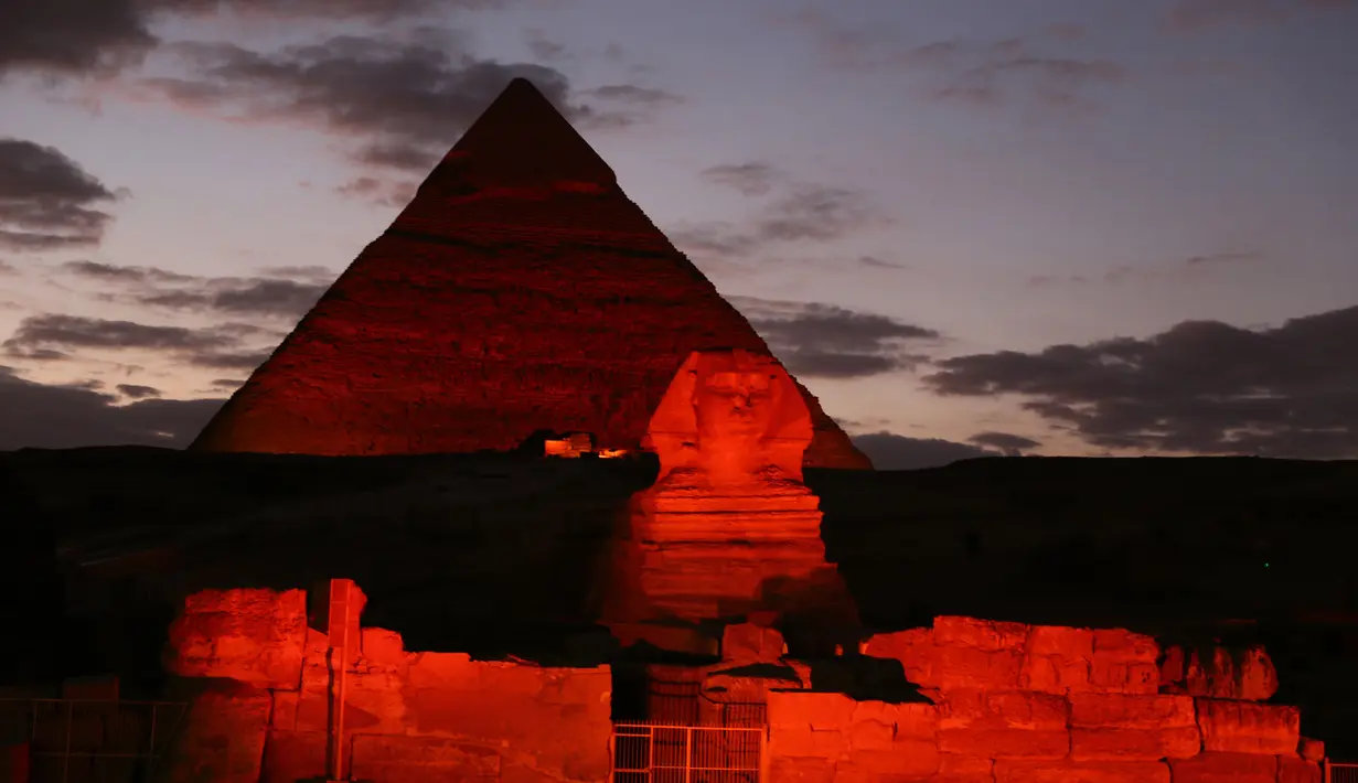 Patung Sphinx dan piramida berwarna merah saat pertunjukan cahaya dan suara di Giza, Mesir, Kamis (23/1/2020). Pertunjukan tersebut digelar sebagai bagian dari perayaan Tahun Baru Imlek. (Xinhua/Ahmed Gomaa)
