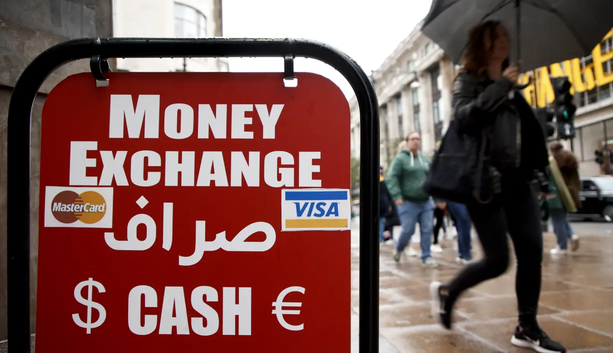 Orang-orang berjalan melewati biro penukaran mata uang di London, Senin, 26 September 2022. Poundsterling pada hari Senin jatuh ke rekor terendah terhadap dolar Amerika Serikat (AS) sejak desimalisasi pada tahun 1971. (AP Photo/David Cliff)