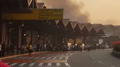 Sejumlah penumpang melihat kebakaran yang terjadi di Terminal 2E di Bandara Soekarno Hatta, Jakarta, Minggu (5/7/2015).  Kebakaran di Terminal 2E ini membuat panik ribuan penumpang yang sedang menunggu jadwal penerbangan. (Twitter@avgustin88)