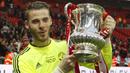 Pemain Manchester United, David de Gea berpose bersama trofi FA Cup setelah memenangkan laga final melawan Crystal Palace di Stadion Wembley, London, 21 Mei 2016. De Gea tercatat berhasil mempersembahkan satu trofi FA Cup selama 12 tahun berkarier di Manchester United. (AFP/Ian Kington)