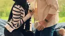 Sebagai pengantin baru, Irish Bella tampil mengenakan cardigan putih garis hitam dipadukan kerudung dan inner dress warna senada. Suami tampil dengan outer dipadukan celana denim. [@_irishbella_]