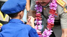 Kapolri Jenderal Polisi Badrodin memberikan hadiah kepada seorang anak kecil dalam peringatan HUT ke65 Pol Airud di Markas Korps Direktorat Polisi Udara Baharkam Polri, Pondok Cabe, Pamulang, Tangerang Selatan, Senin (1/12). (Liputan6.com/Yoppy Renato)